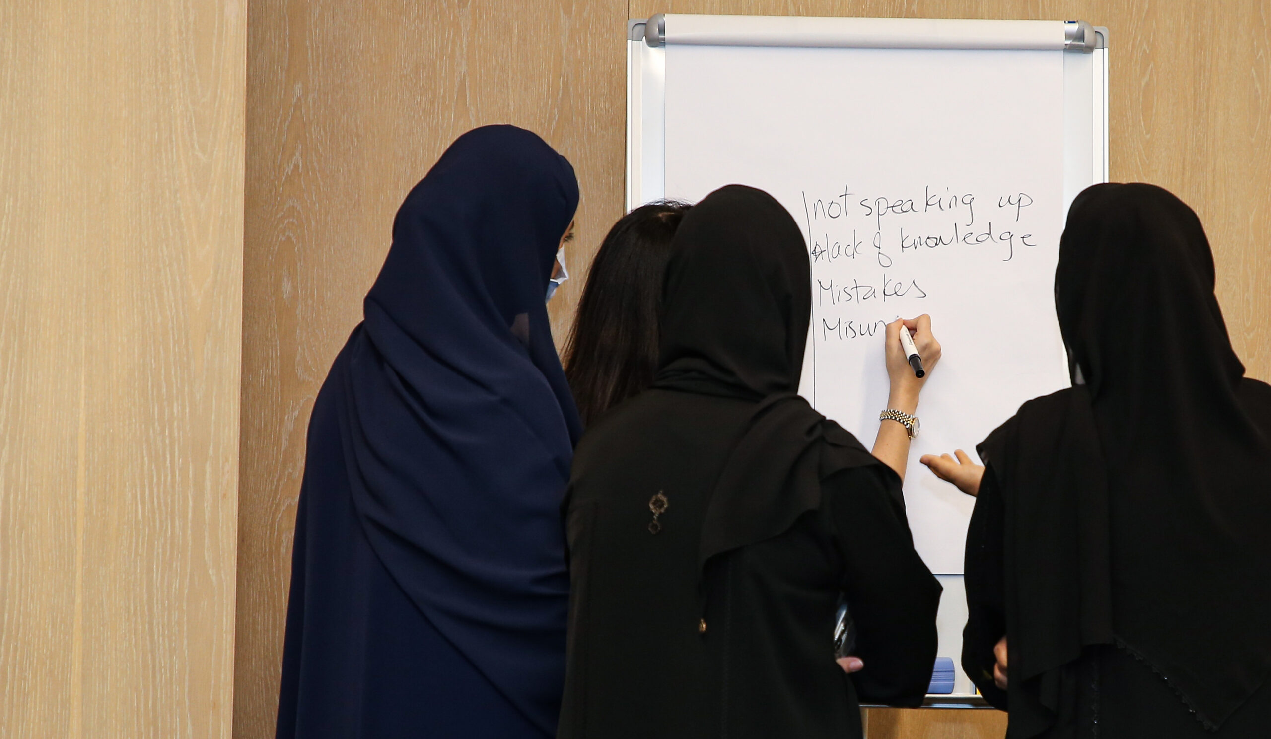 Emirati women work on whiteboard at Aurora50's Pathway20 workshop, May 2022