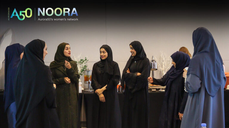 A photo from Aurora50's NOORA women's network (with logo) from a meet-up on 9 January 2025. The workshop focused on social capital and two male allies were invited to attend. In this photo, seven veiled women network.