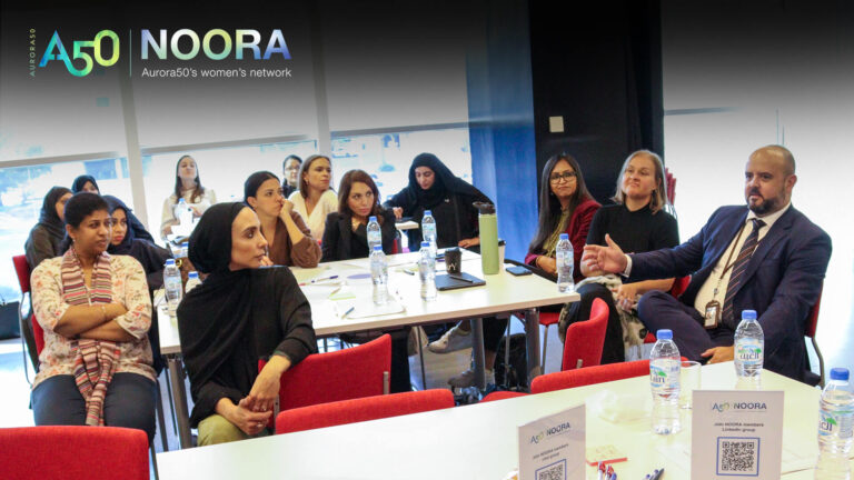 A photo from Aurora50's NOORA women's network (with logo) from a meet-up on 9 January 2025. The workshop focused on social capital and two male allies were invited to attend. In this photo, one of the men speaks while women listen.