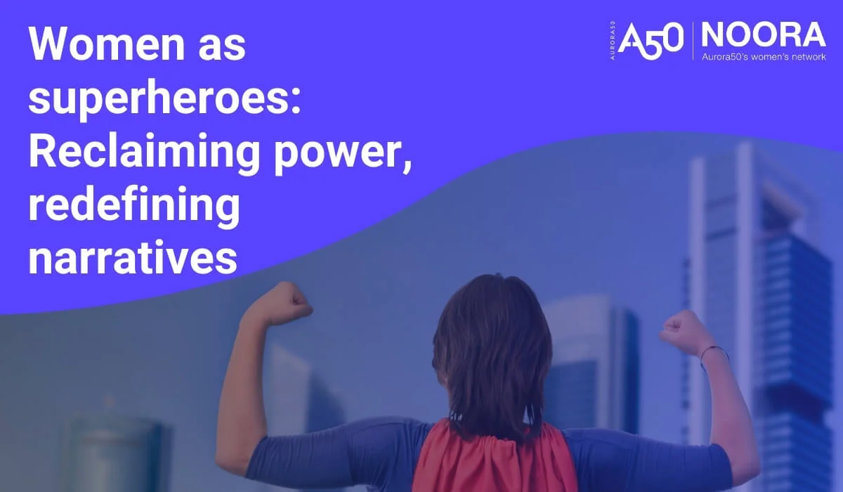 Blog post graphic shows Aurora50 and NOORA logos with strapline Aurora50's women's network, plus headline 'Women as superheroes: Reclaiming power, redefining narratives' and an anonymous image of a woman shown from behind flexing her arm muscles in a Superman pose and wearing a blue superhero costume and red cape, in front of several skyscrapers.